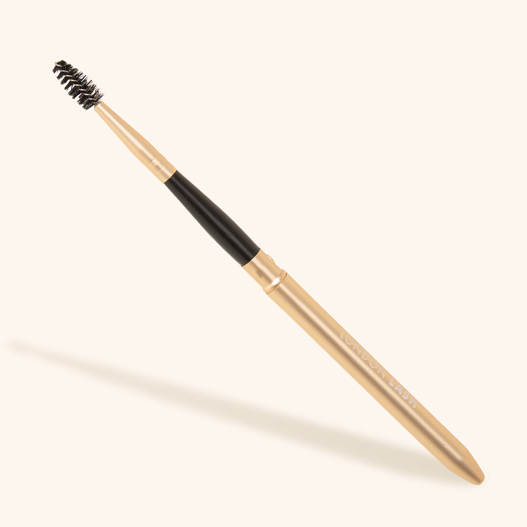 eyelash brush with protective metallic cap in gold colour