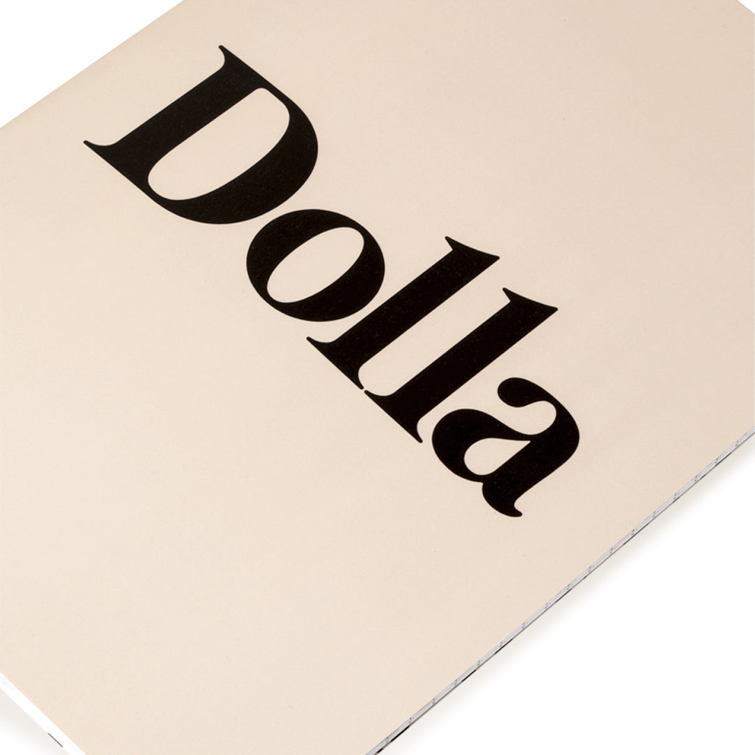 close up to a beige note book with title DOLLA on the cover