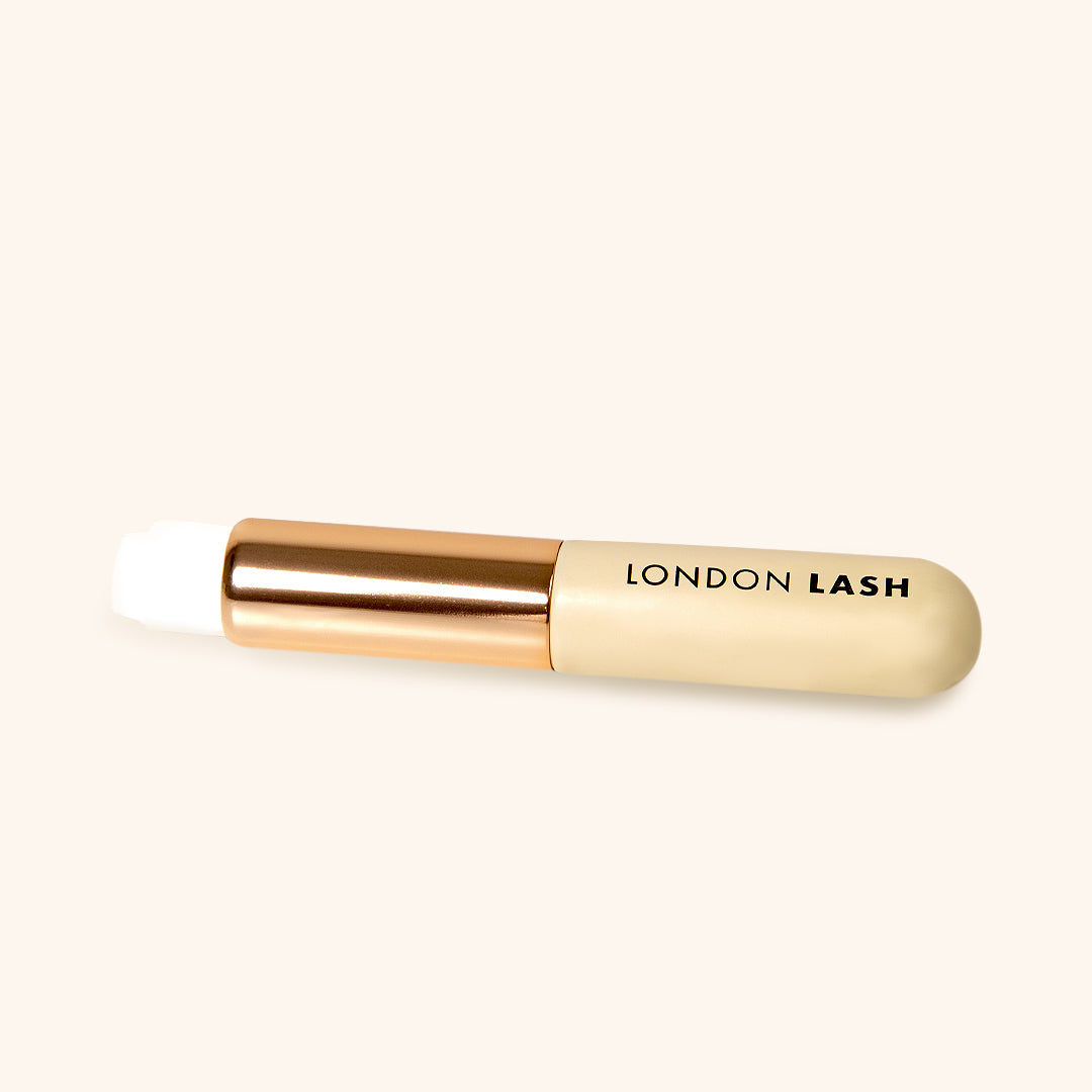lash cleansing brush with white soft fibers and metallic gold and wooden beige handle