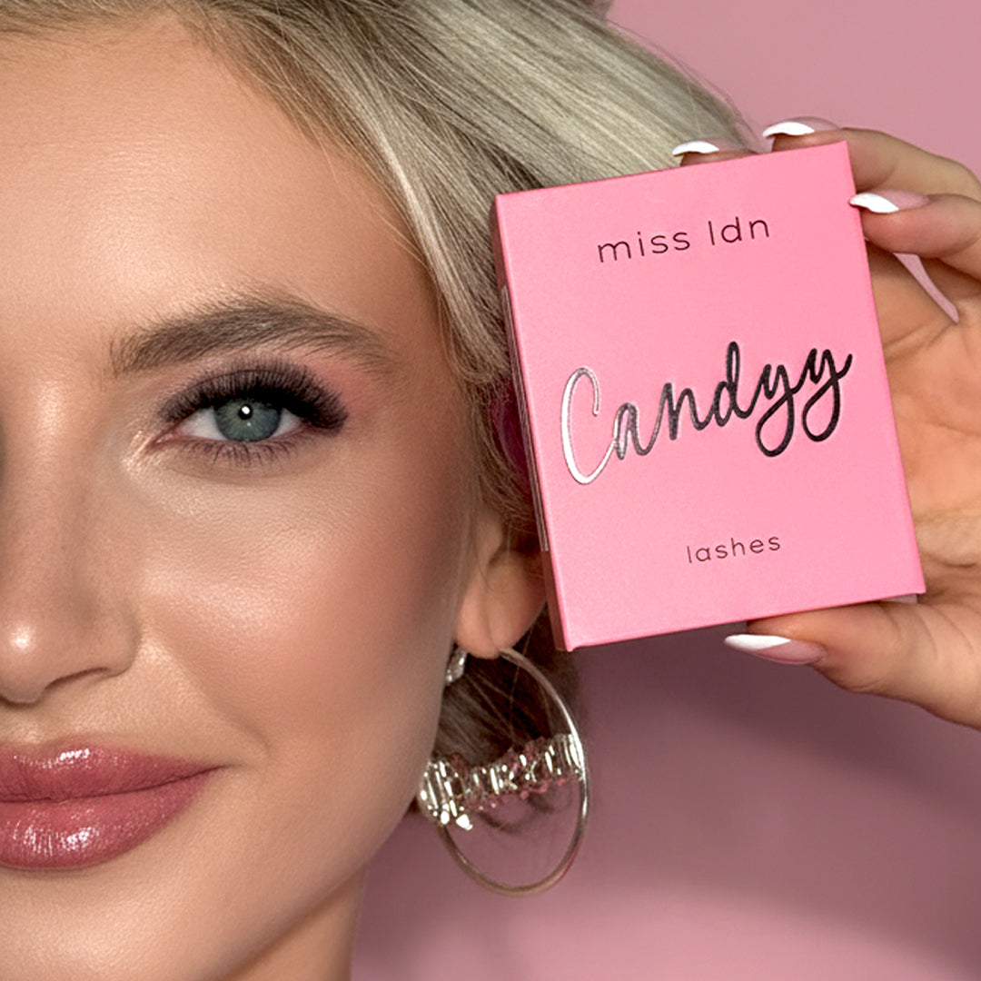 Close up of a model face, wearing Candyy lash extensions and holding the lash tray 