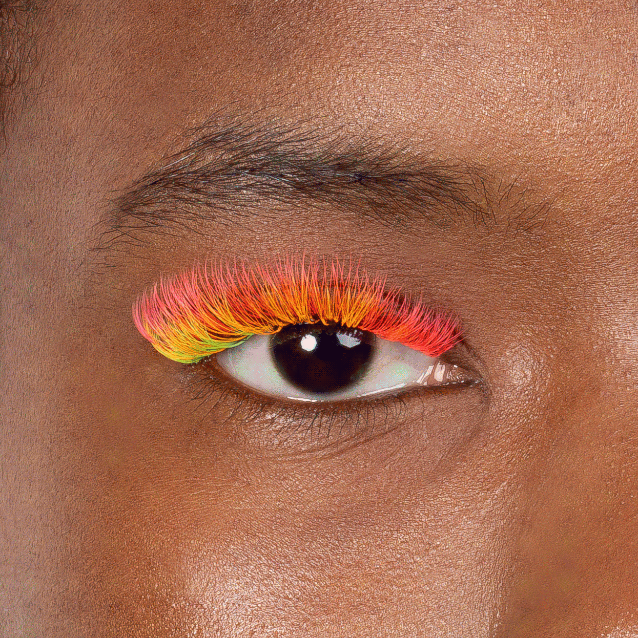Close up of model's eye wearing London Lash neon coloured volume eyelash extensions