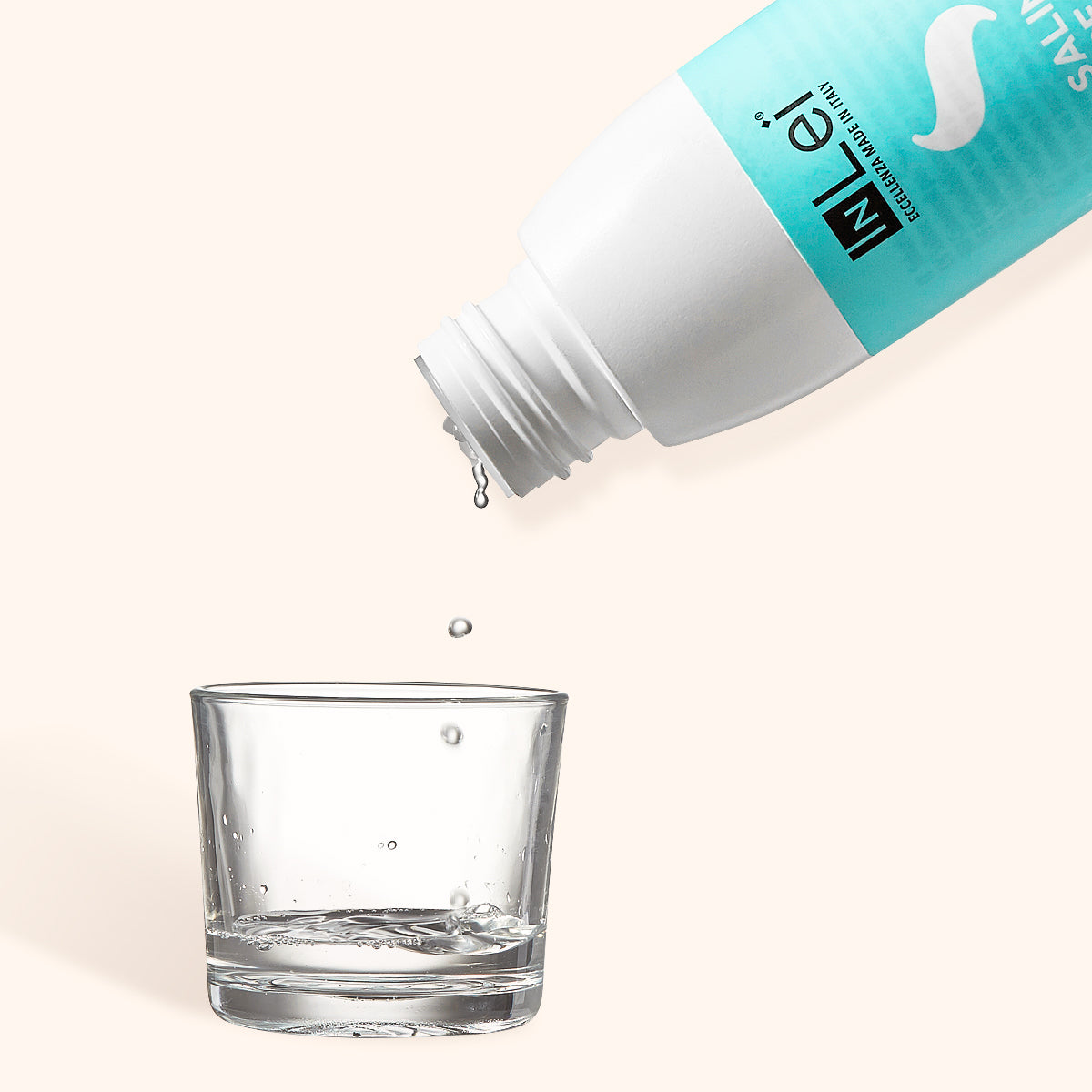 InLei Pre-treatment Saline Solution bottle pouring into a glass, ideal for cleansing lashes and eyebrows.